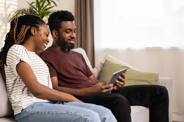 istock Happy Couple Relaxing On Couch With Digital Tablet 2152225195