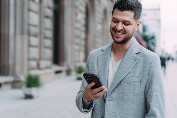 istock Young smiling man using smartphone on the street. 2152226512