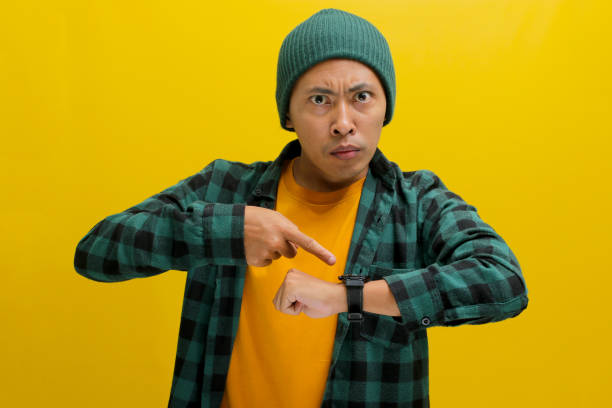 istock Asian Man Taps Wristwatch 2152228946