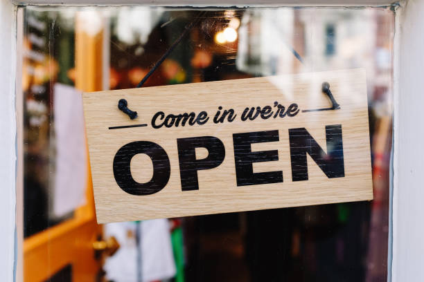 istock A sign hanging from a window that says Come in We're Open 2152231644
