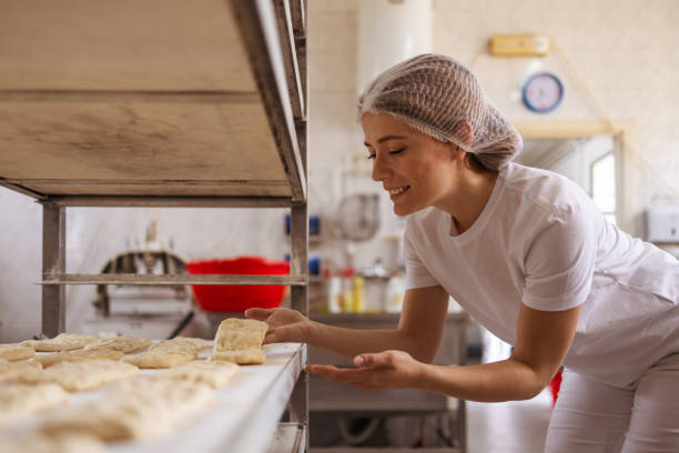 istock Female baker baking fresh bread in the bakehouse 2152232998