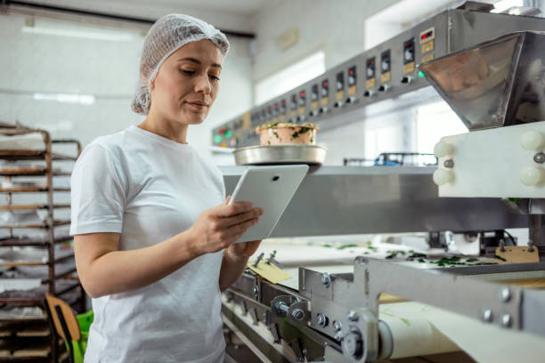 Female Baker With Digital Tablet in the Bakery