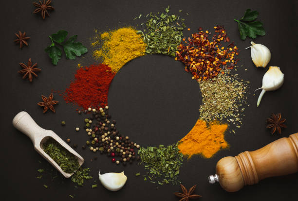 Circle frame composition of spices and herbs isolated on dark background with copy space. Frame of Indian spices and herbs. Ingredients of asian cuisine spices