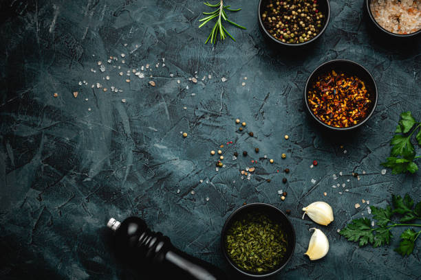 istock Dark stone kitchen background with spices, herbs and kitchen utensils. Free space for text. Top view. Rustic style. 2152234594