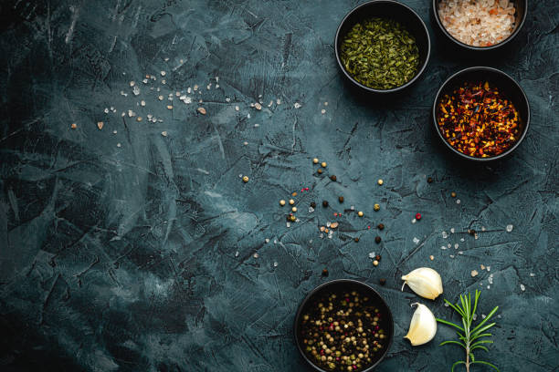 istock Dark stone kitchen background with spices, herbs and kitchen utensils. Free space for text. Top view. Rustic style. 2152234618