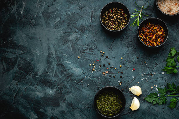 istock Dark stone kitchen background with spices, herbs and kitchen utensils. Free space for text. Top view. Rustic style. 2152234655