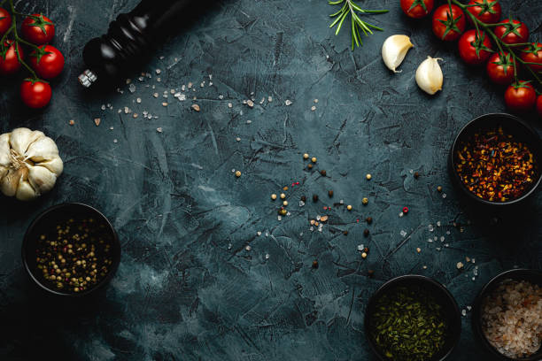 istock Dark stone kitchen background with spices, herbs and kitchen utensils. Free space for text. Top view. Rustic style. 2152234662