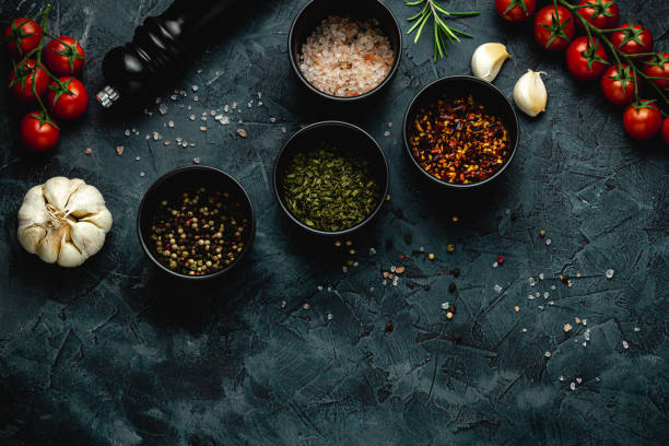 istock Dark stone kitchen background with spices, herbs and kitchen utensils. Free space for text. Top view. Rustic style. 2152234669