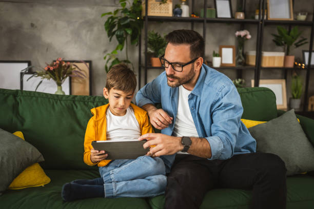 istock Father look son while he play video games or browse internet on tablet 2152239372