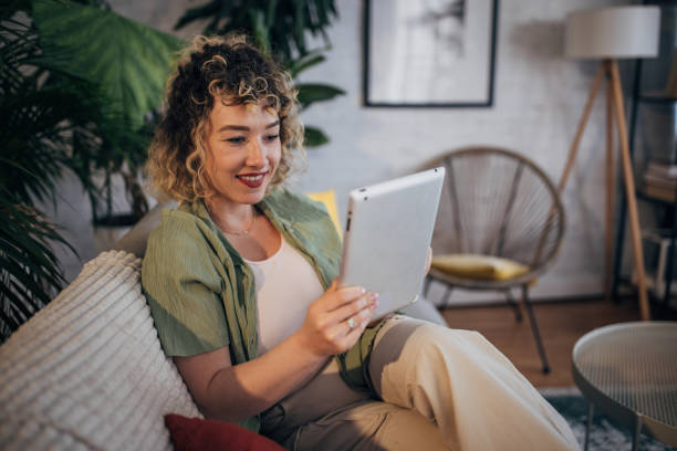 istock Smiling young woman using tablet at home 2152241598