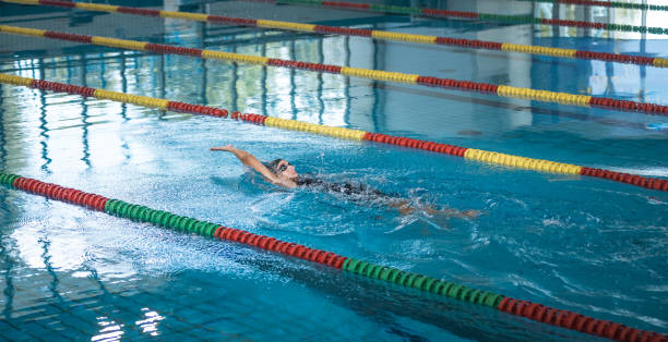 istock Female athlete performing the backstroke swim technique 2152242224