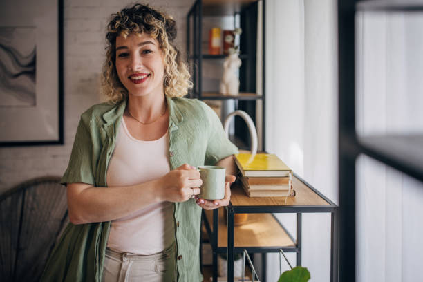 istock Smiling woman with coffee in stylish home office 2152243567