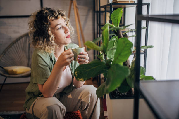 istock Woman enjoying coffee by indoor plants 2152243692