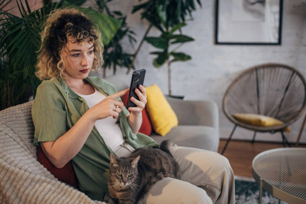istock Woman relaxing with cat while using smartphone at home 2152245026