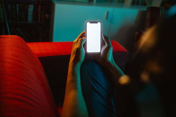 Holding smart phone with blank screen at home