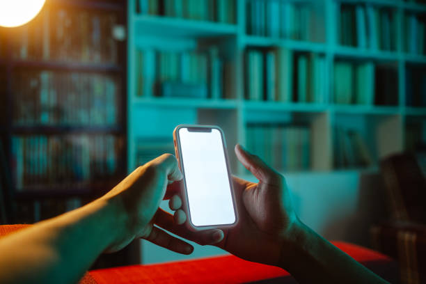istock Holding smart phone with blank screen at home 2152245298