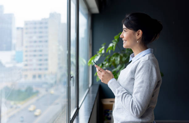 istock Businesswoman texting on her mobile phone at the office 2152247360