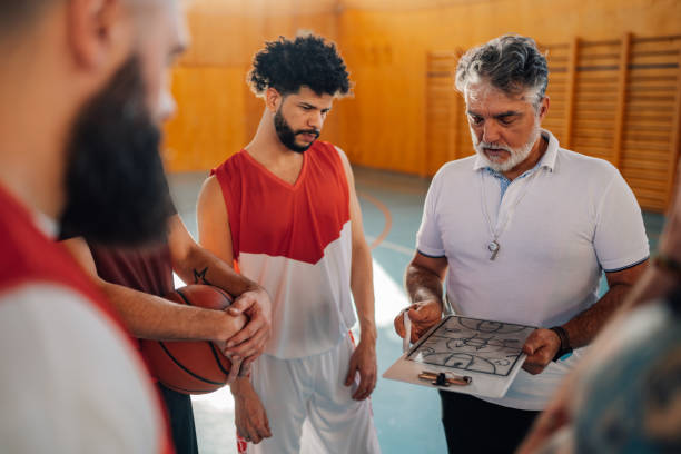 istock An old basketball coach working on game plan with his interracial team. 2152254670