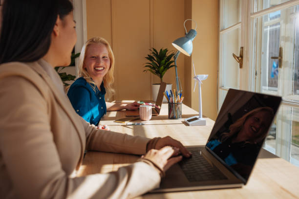 istock Two female colleagues working on their laptops and smiling 2152254892