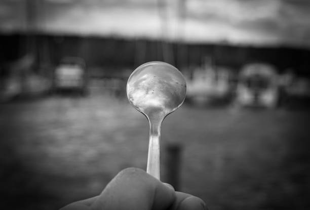 Cropped hand holding a spoon outdoors