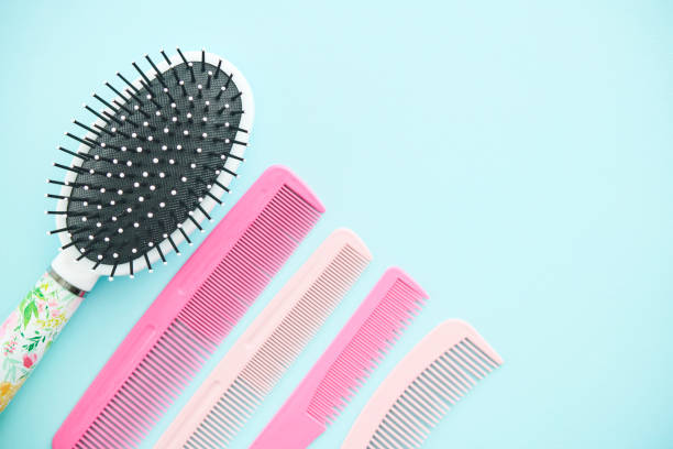 A hairbrush and collection of combs on a blue background with space for text