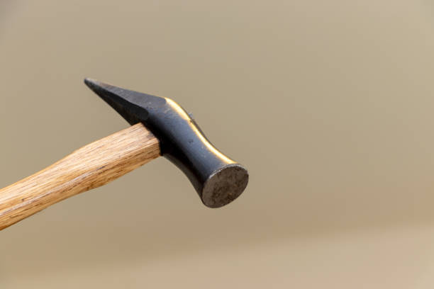 istock The black luster head of a hammer being swung down 2152258679