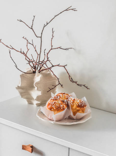 istock Dry twigs in a creative ceramic vase, fresh brioche buns on a white table. Aesthetic still life 2152259796