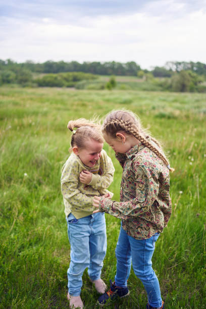 istock sisters hug and protect each other from the wind in the field 2152261486