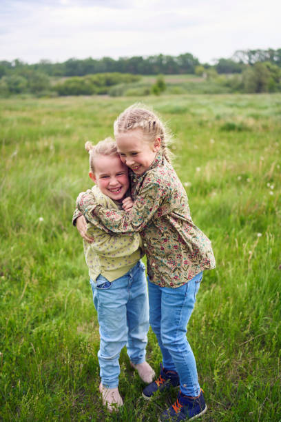 istock sisters hug and protect each other from the wind in the field 2152261532