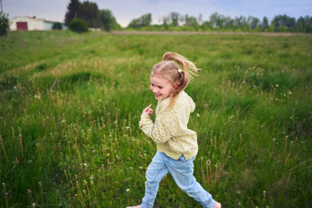 istock girls play catch up in a field 2152261624