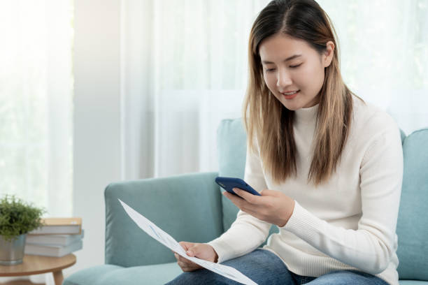 istock woman use phone scan barcode or QR codes to pay credit card bill after receiving document invoice. payment, receive, paying electricity, digital payments, technology, scanning, financial transactions 2152262199