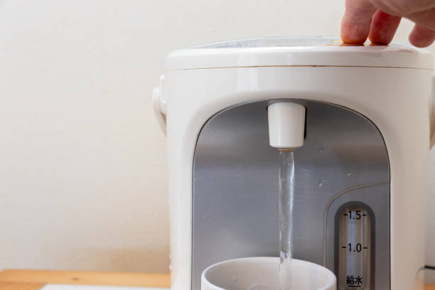 istock pour hot water into a mug from the water heater 2152263941