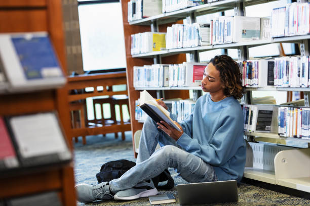 istock Multiracial teenage boy studying in library 2152265284