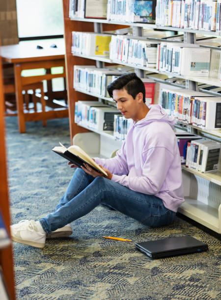 istock Multiracial teenage boy studying in library 2152265466