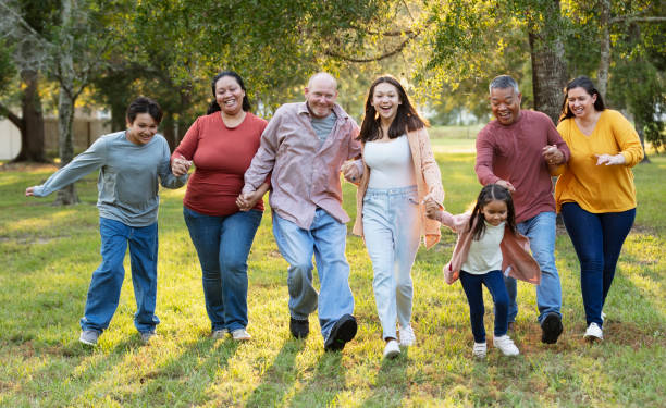 istock Multiracial extended family run playfully holding hands 2152269703