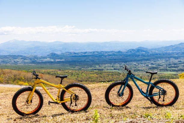 Two old bicycles leaning against yellow building