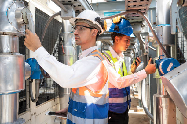 istock Two Engineers are inspecting a large building or industrial facility's cooling system for the air conditioning on rooftop building 2152277454