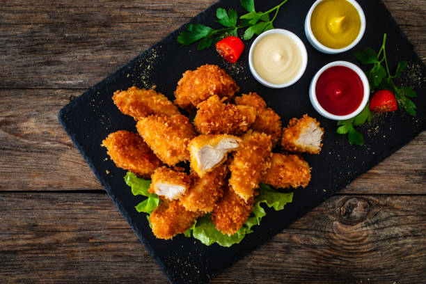 istock Fried chicken nuggets wit ketchup mayonnaise and mustard on wooden table 2152278070
