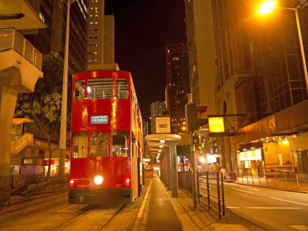 Night Hong Kong street in the night with red retro style Double Decker tram on the stop