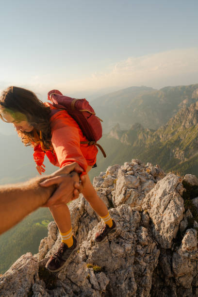 istock Woman has a helping hand while climbing in mountains 2152281884