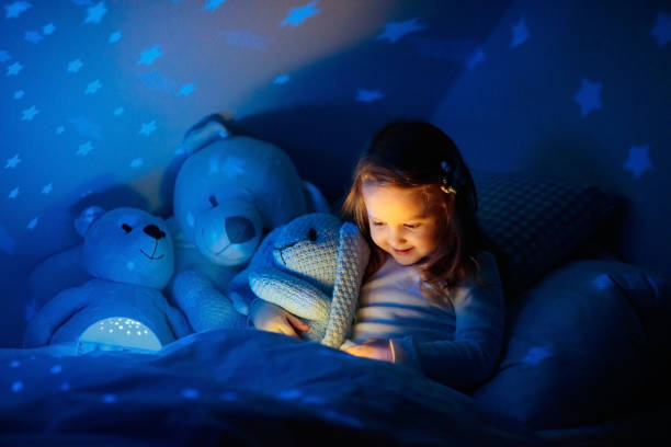 istock Little girl reading a book in bed 2152284381