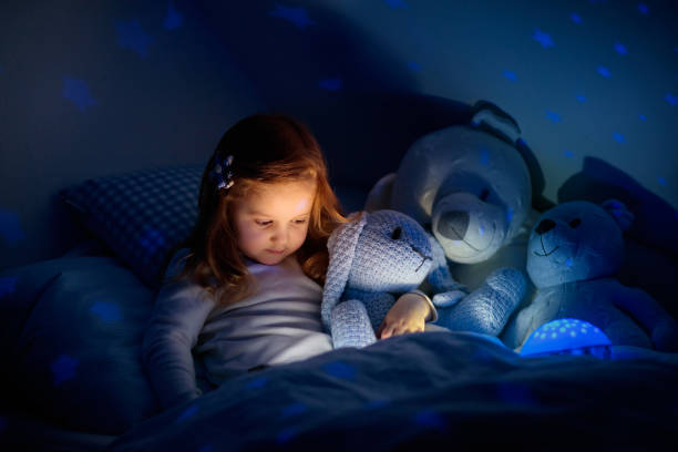 istock Little girl reading a book in bed 2152287677