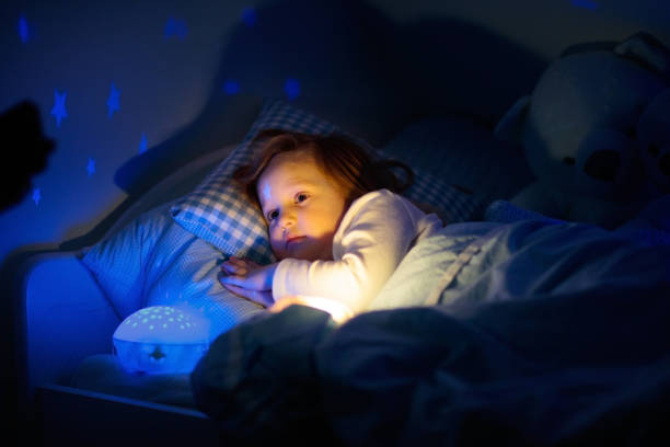 istock Little girl reading a book in bed 2152287945