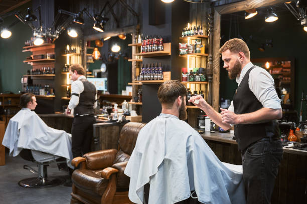 istock Professional barbers working on client hair in barbershop. 2152288605