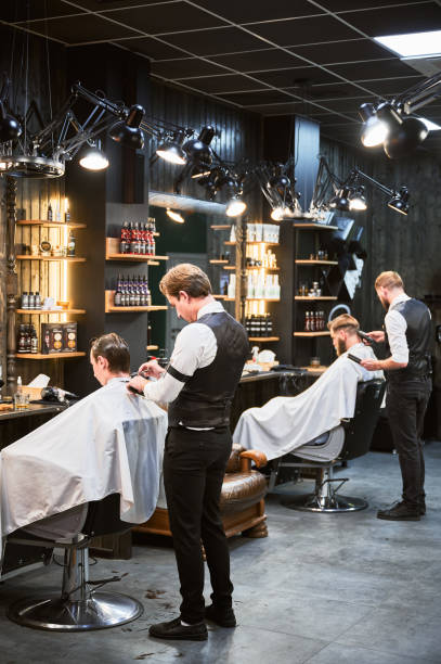 istock Professional barbers working on client hair in barbershop. 2152288609