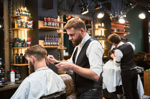 istock Professional barber using comb and electric shaver to cut side hair. 2152288610