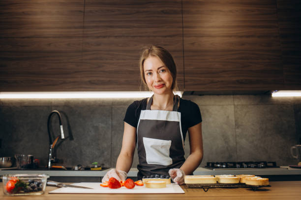 istock Woman in kitchen preparing cream puffs 2152293009