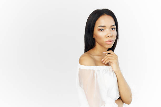pretty woman african appearance cosmetics white dresses posing light background. High quality photo