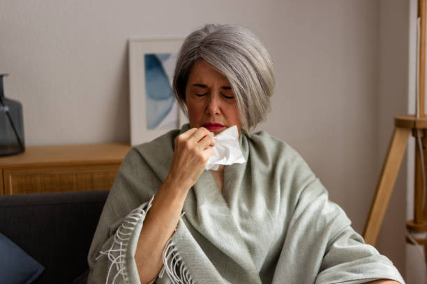 istock Illness at home: mature woman blowing nose 2152294335