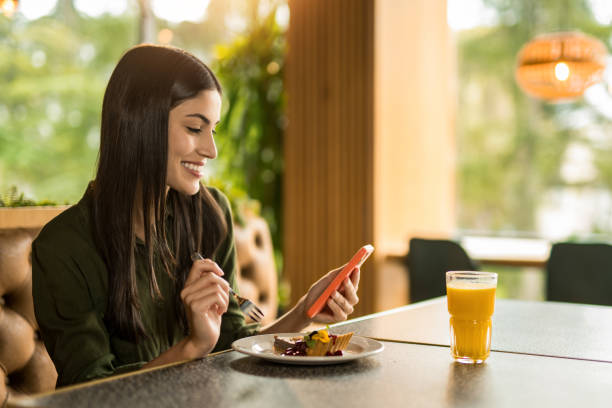 istock Happy woman using phone and having dessert at a restaurant. 2152294648